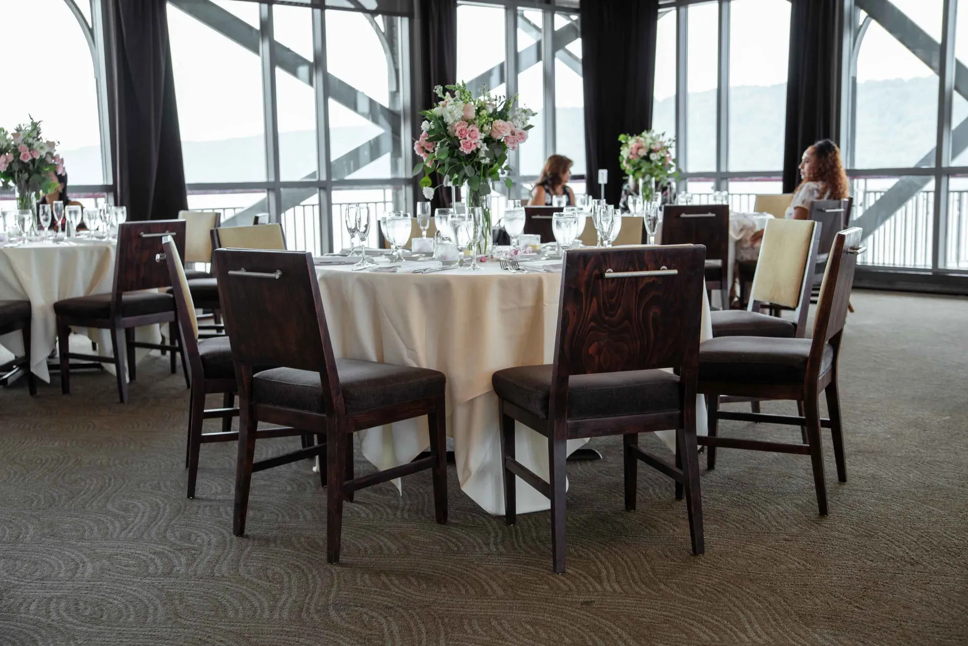 A room with tables and chairs set up for a wedding reception