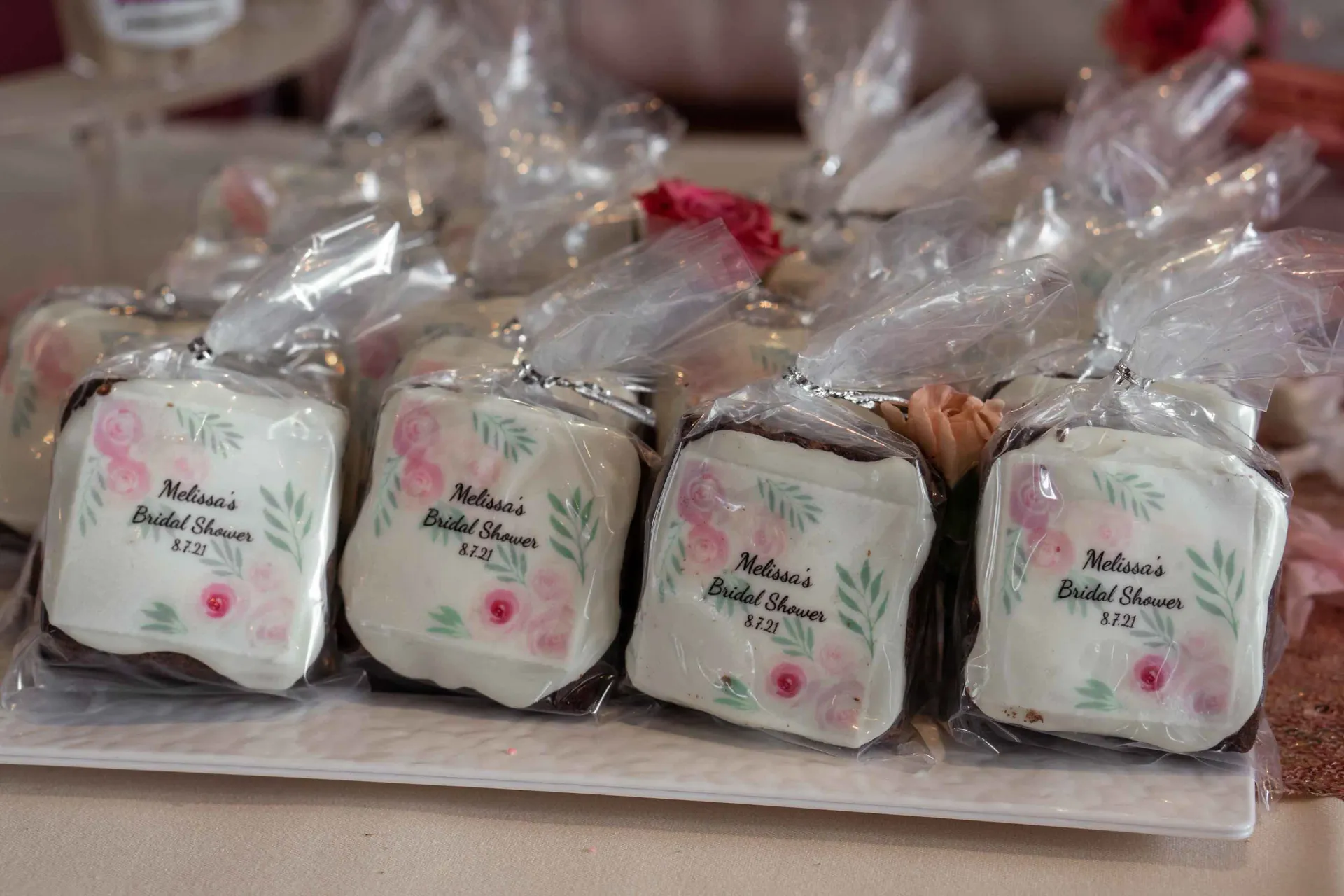 A tray of cookies wrapped in plastic on a table.