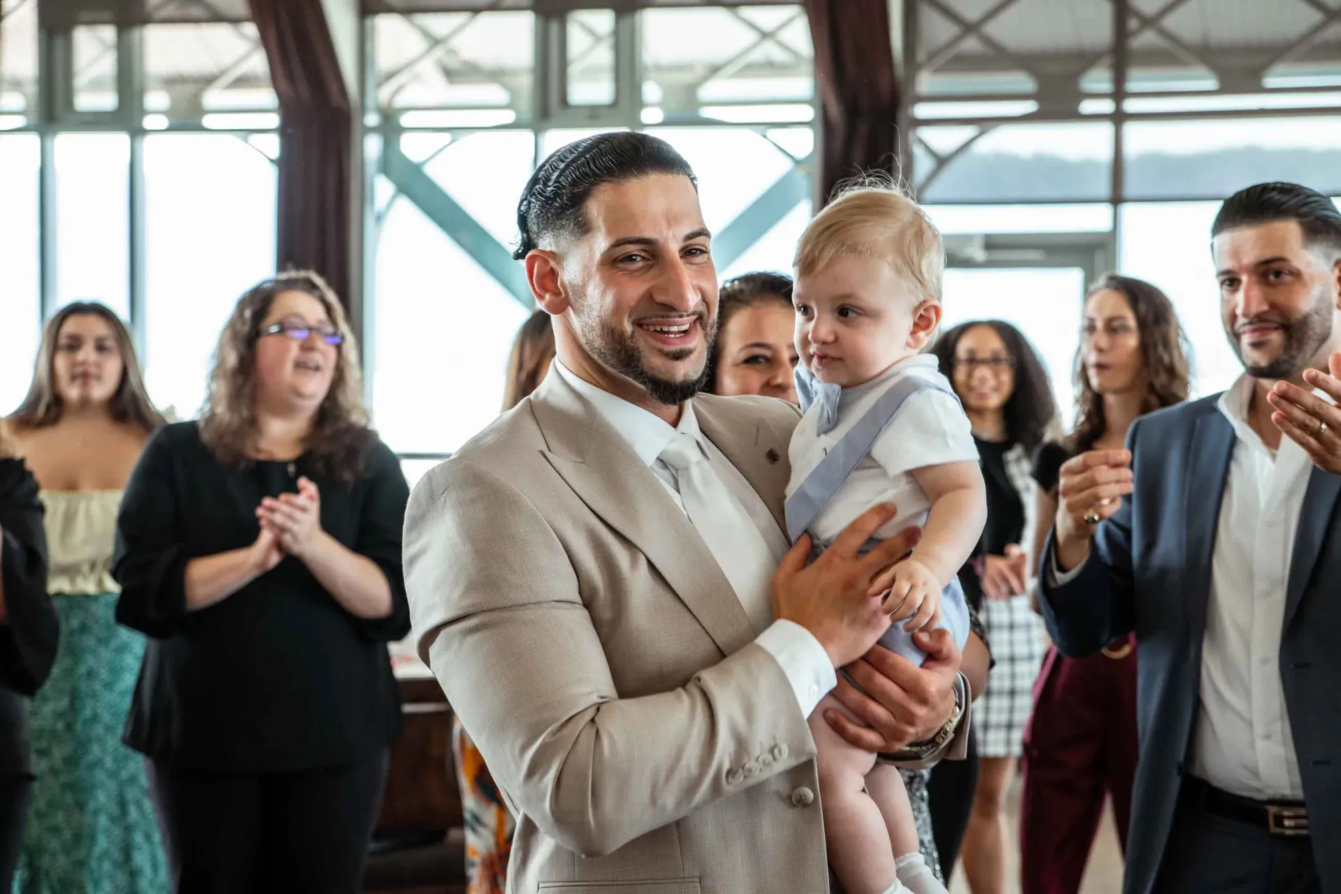 A man in a suit is holding a baby in his arms.