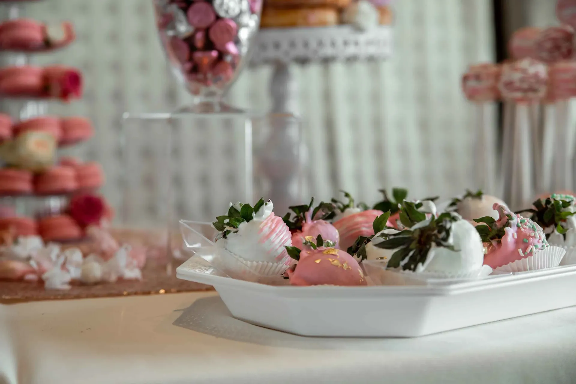 A plate of chocolate covered strawberries on a table.