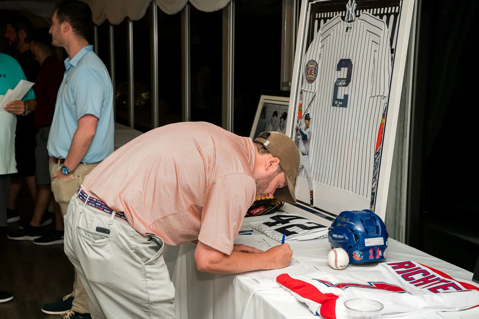 A man is writing on a piece of paper on a table.