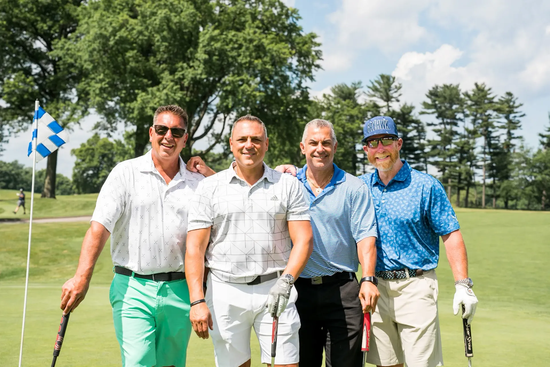 A group of men are posing for a picture on a golf course.