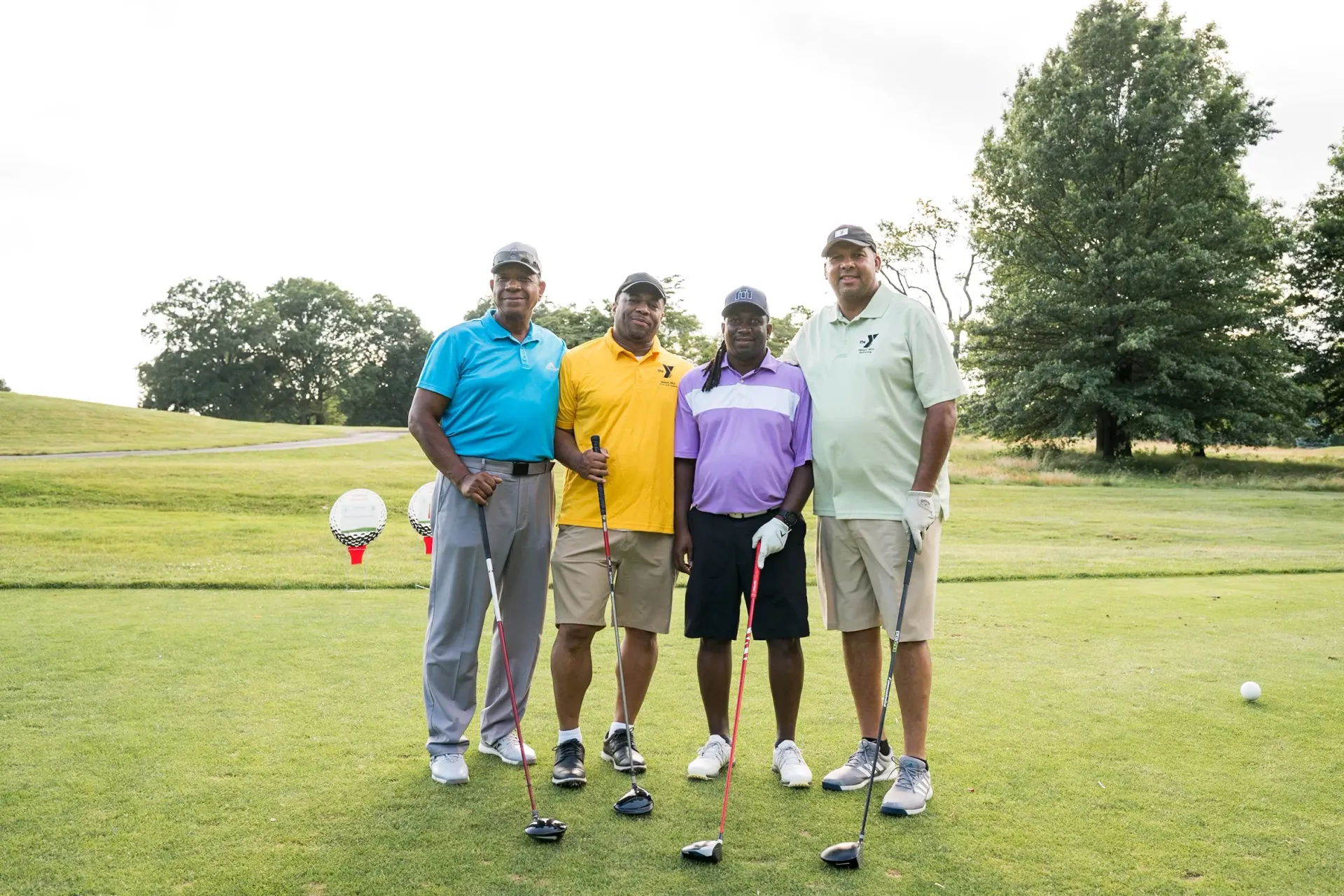 A group of men are posing for a picture on a golf course.