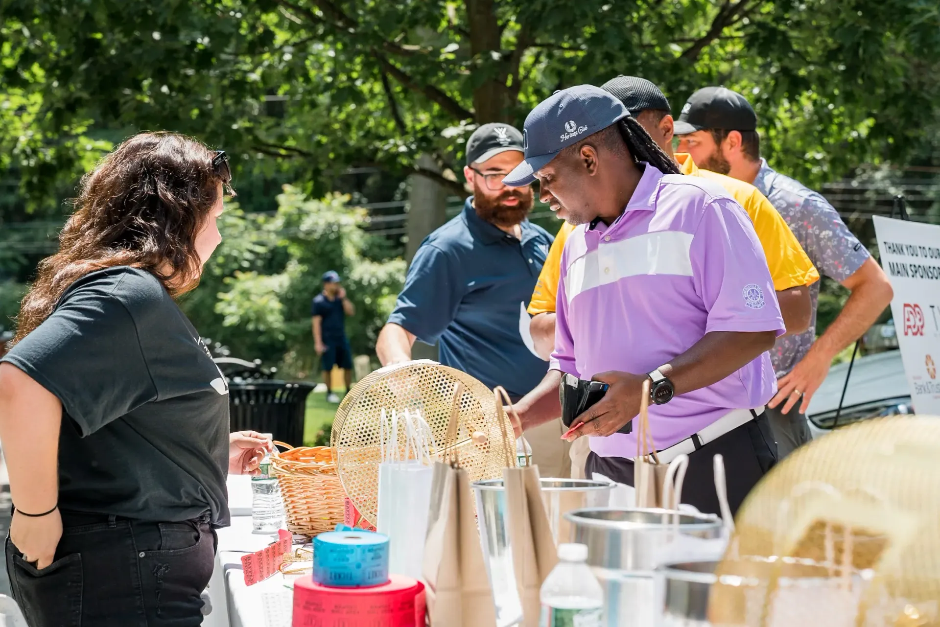 A group of people are standing around a table at a charity event.