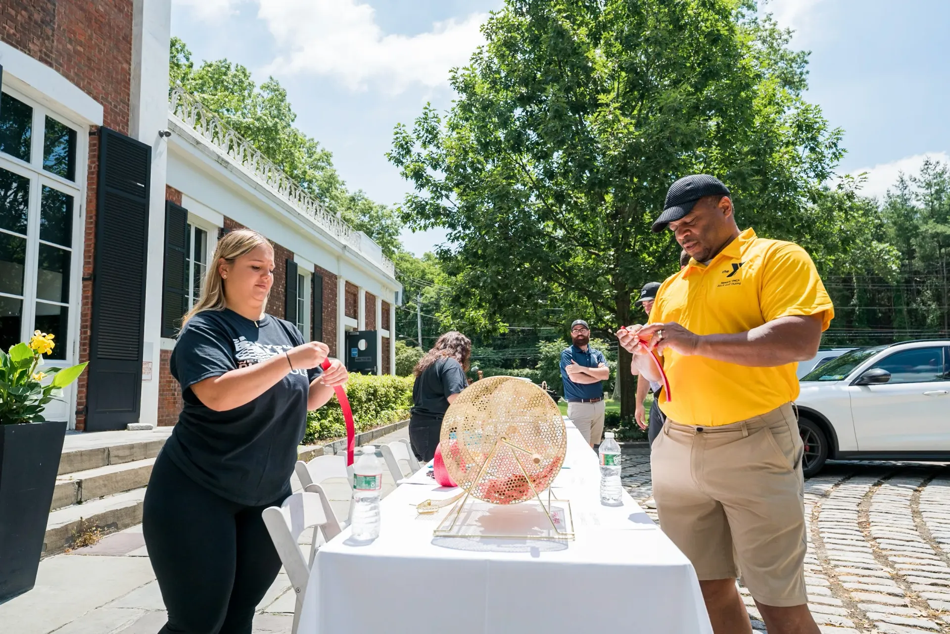 A man and a woman are standing next to a table.