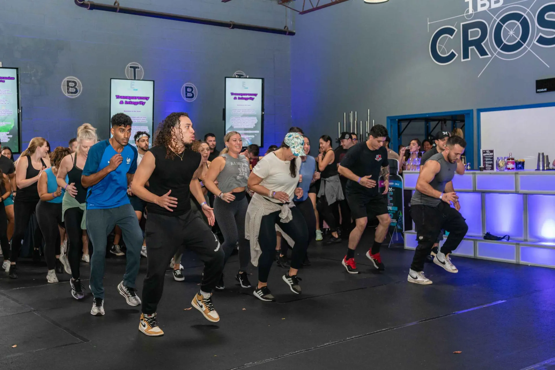 A group of people are dancing in a gym.
