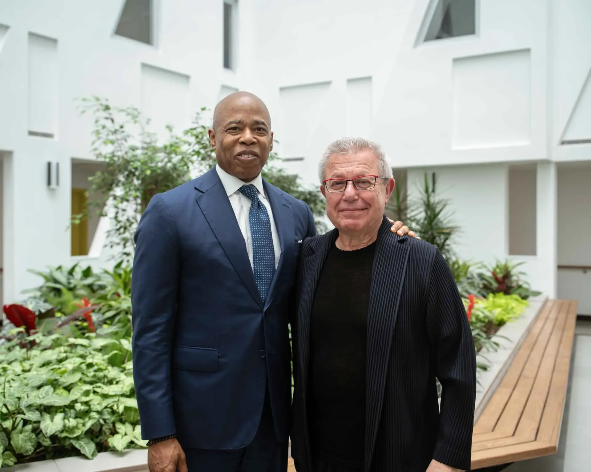 Two men in suits and ties are posing for a picture.