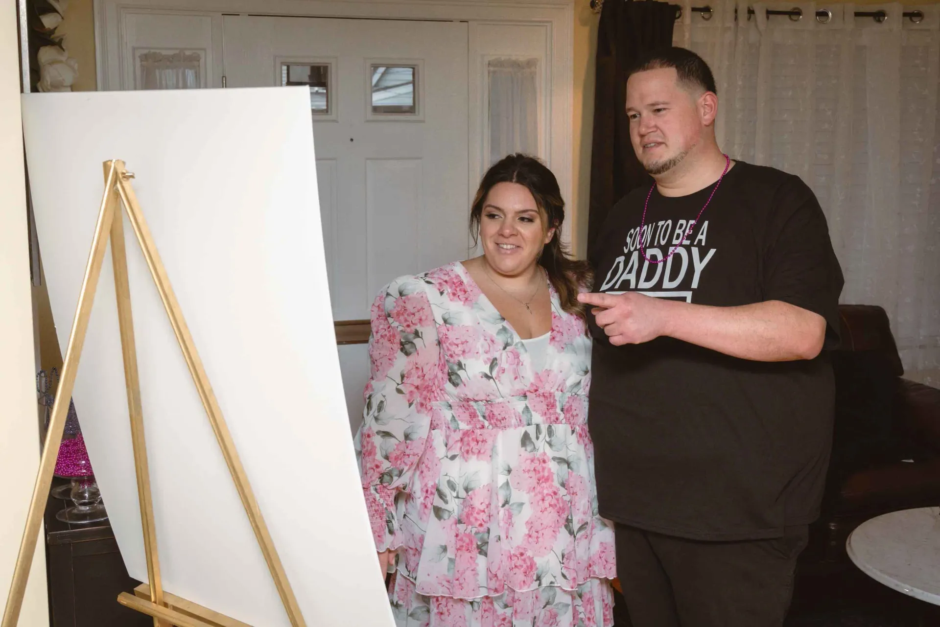 A man and a woman are standing next to each other in front of a white board.