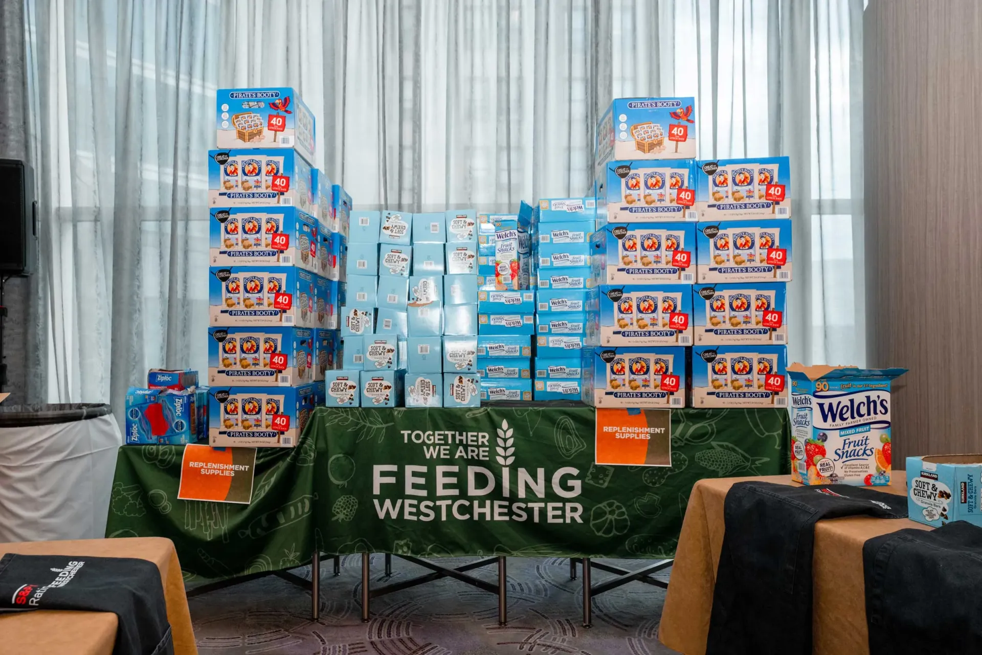 A table with boxes of food on it and a sign that says feeding westchester.