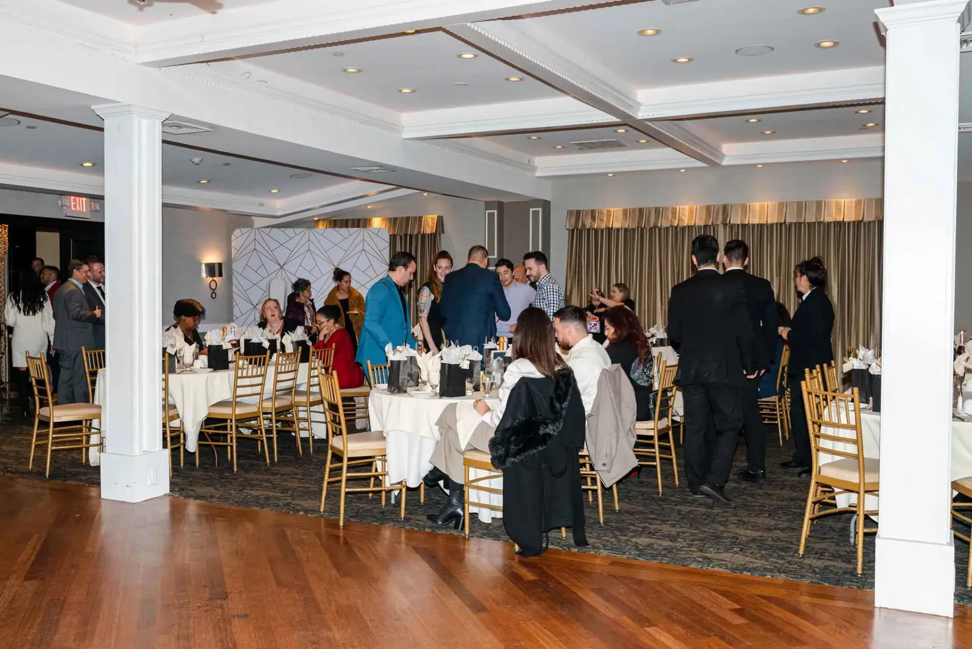 A group of people are sitting at tables in a large room.