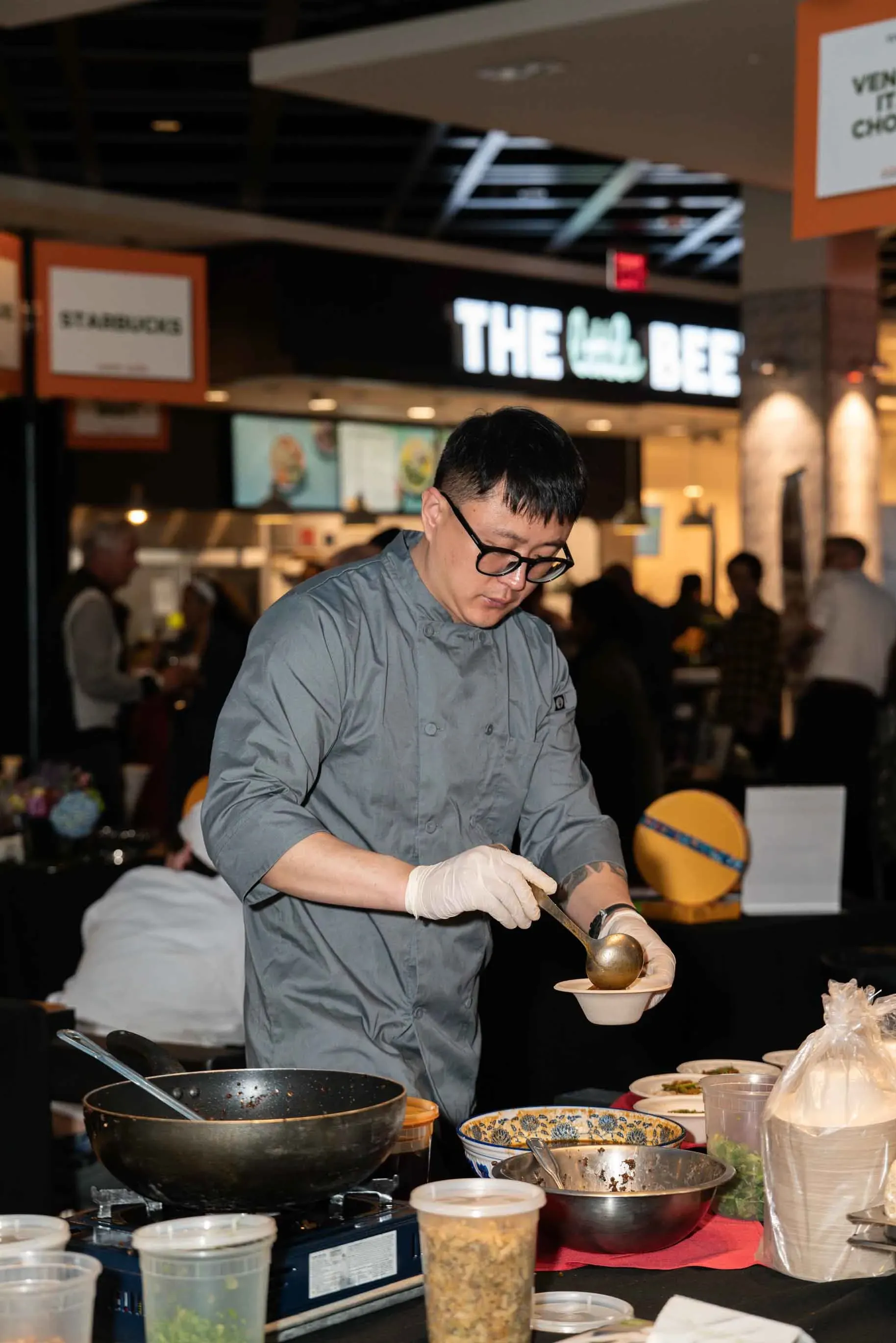 A man is preparing food in front of a restaurant.