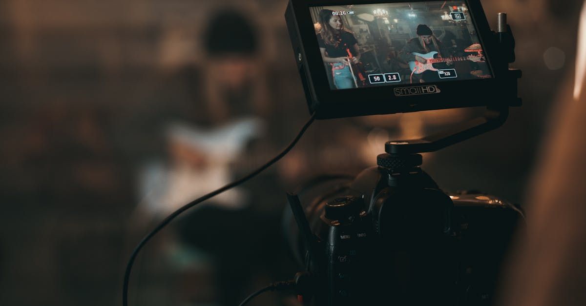 A camera is recording a video of a man playing a guitar.