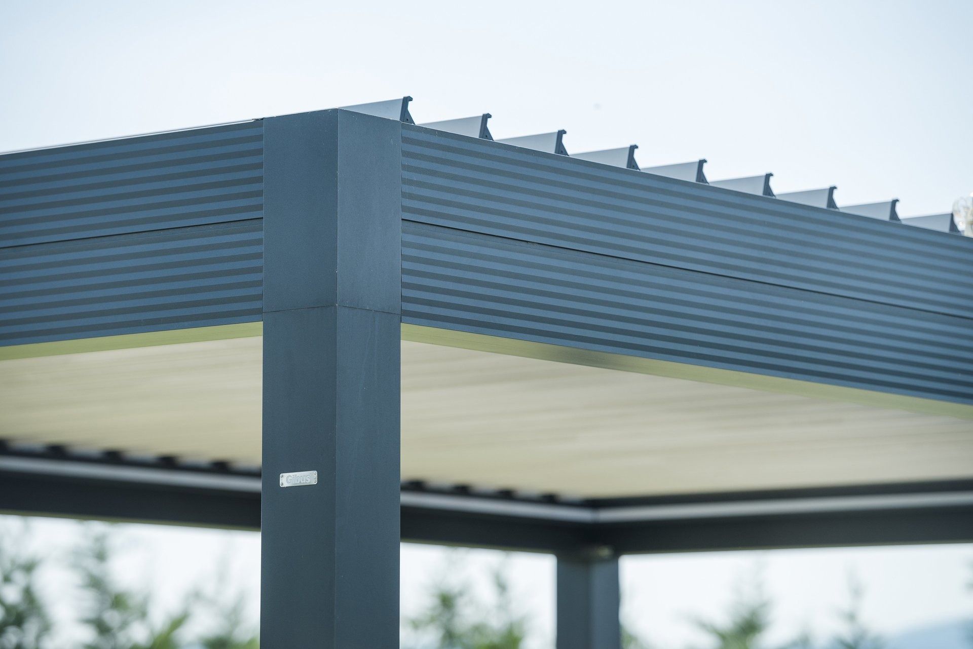 Pergola grigia con parte superiore ondulata e parte inferiore bianca, vista dal basso.