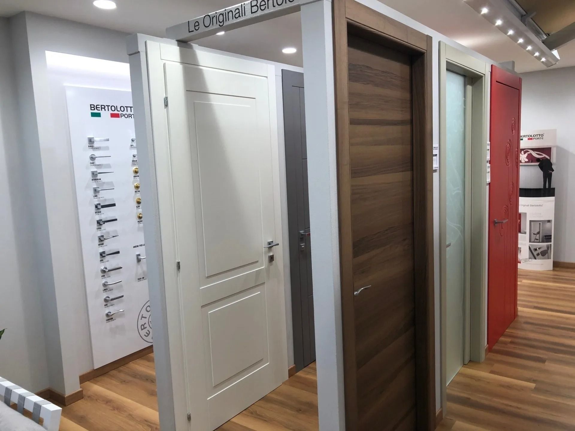 Esposizione di porte interne in vari colori e stili, allestimento showroom.