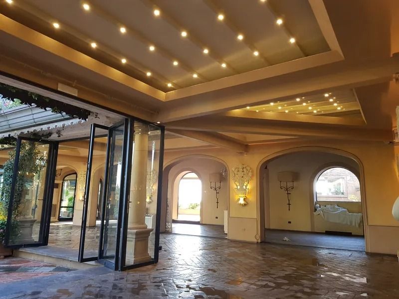 Spazio per eventi al coperto con porte ad arco e porte in vetro che conducono all'esterno.