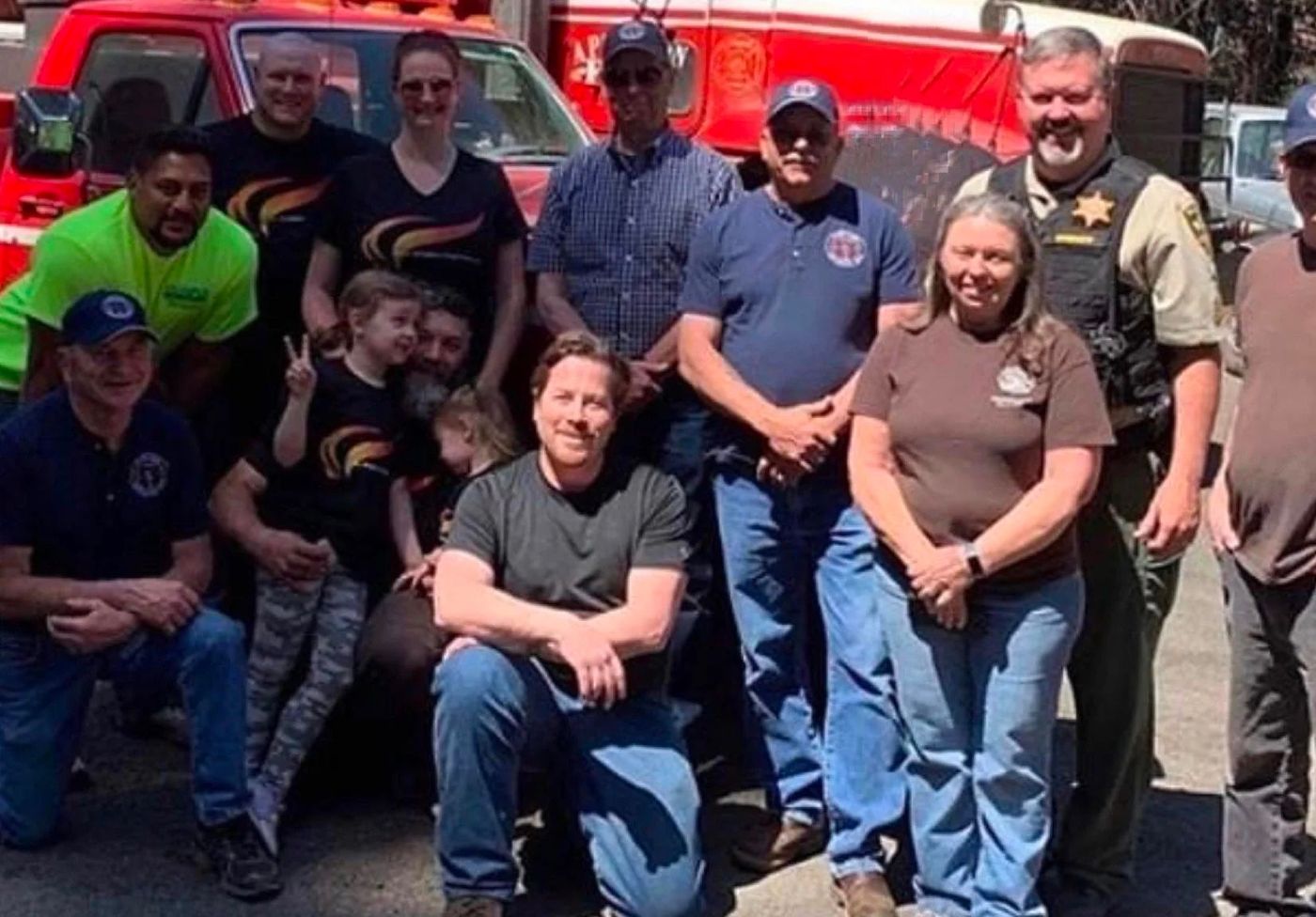 A group of people posing for a picture in front of a fire truck