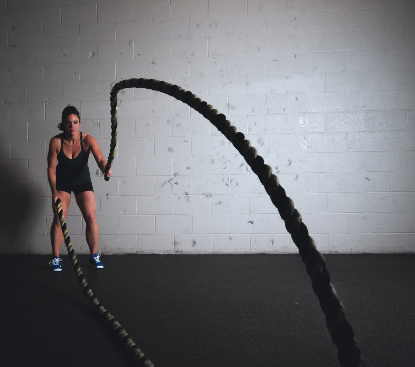 vrouw gebruikt touw voor battle rope training