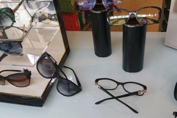 degli occhiali da sole neri fuori e dentro una vetrinetta