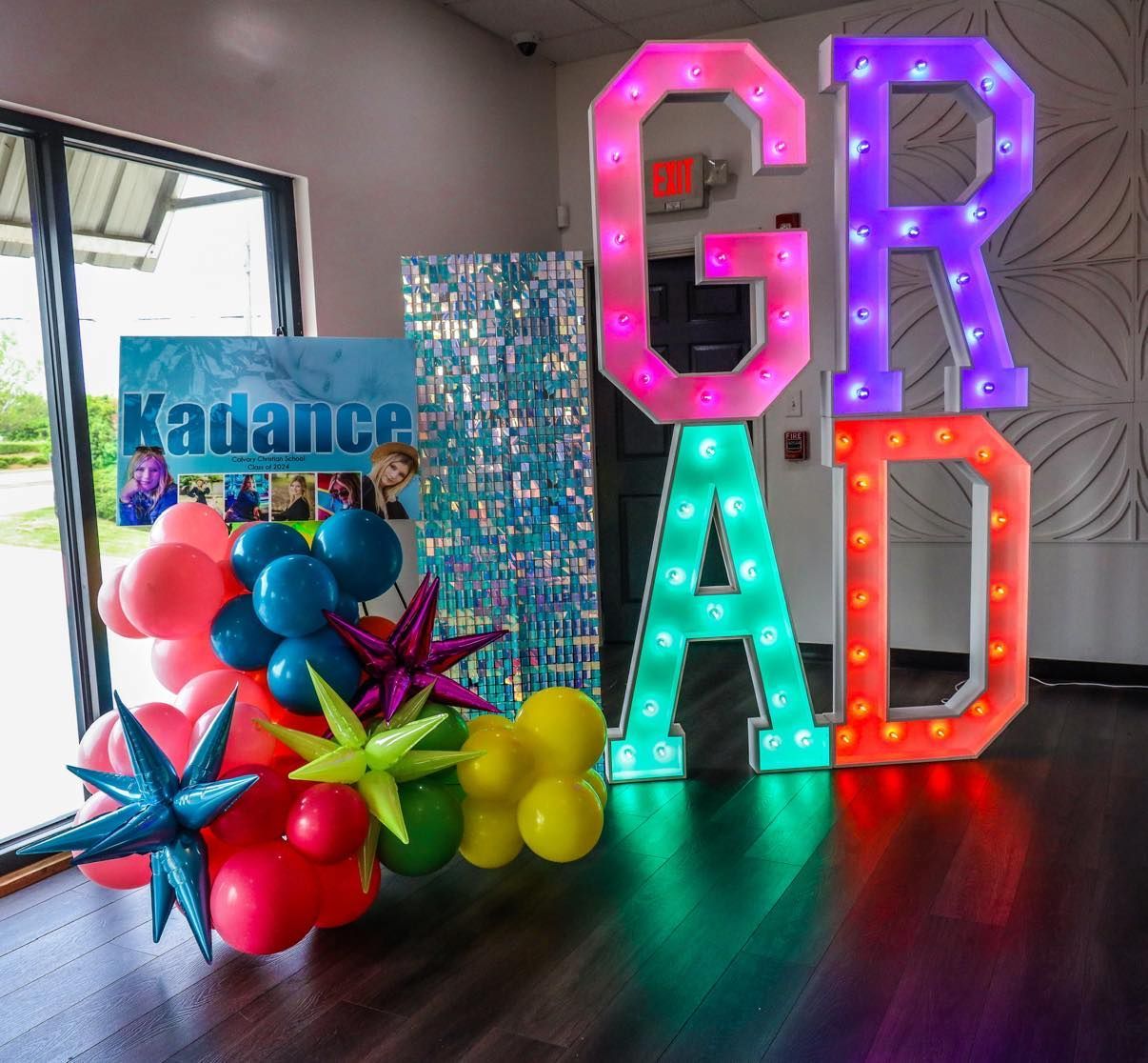 A room with balloons and a sign that says kadance