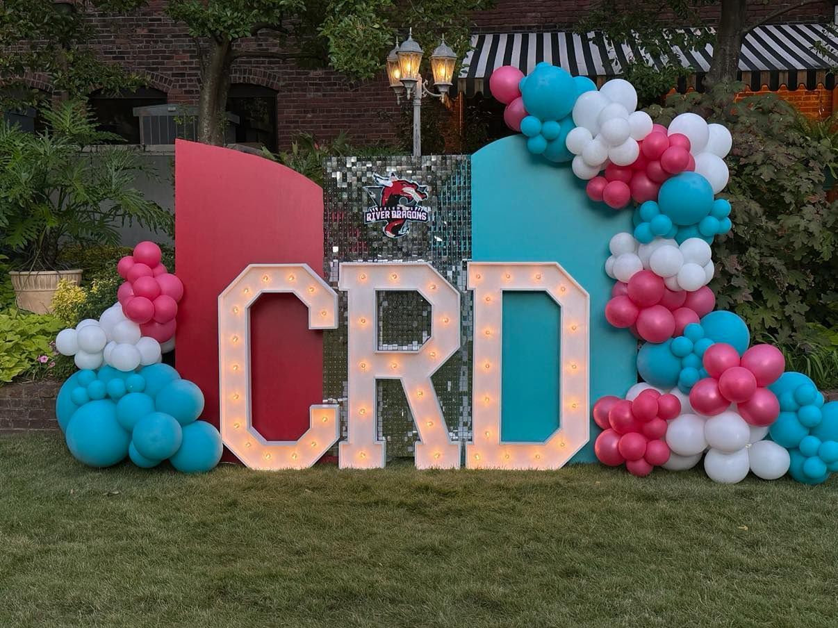 A large sign that says crd is surrounded by balloons.