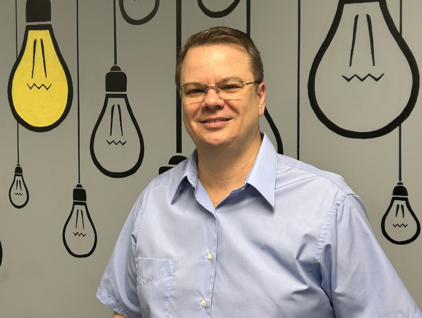 A woman is smiling in a black and white photo.