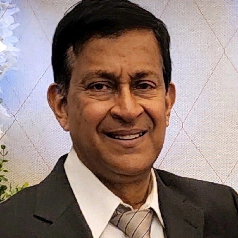 A man in a suit and tie is smiling for the camera.