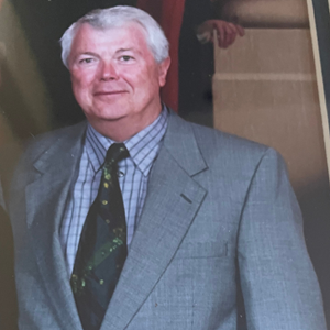 A man in a suit and tie is smiling for the camera