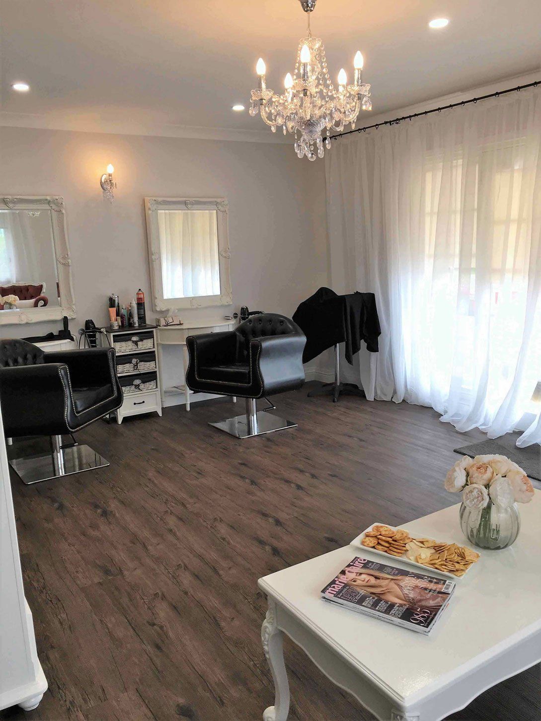 brown floor with two black chairs and white table