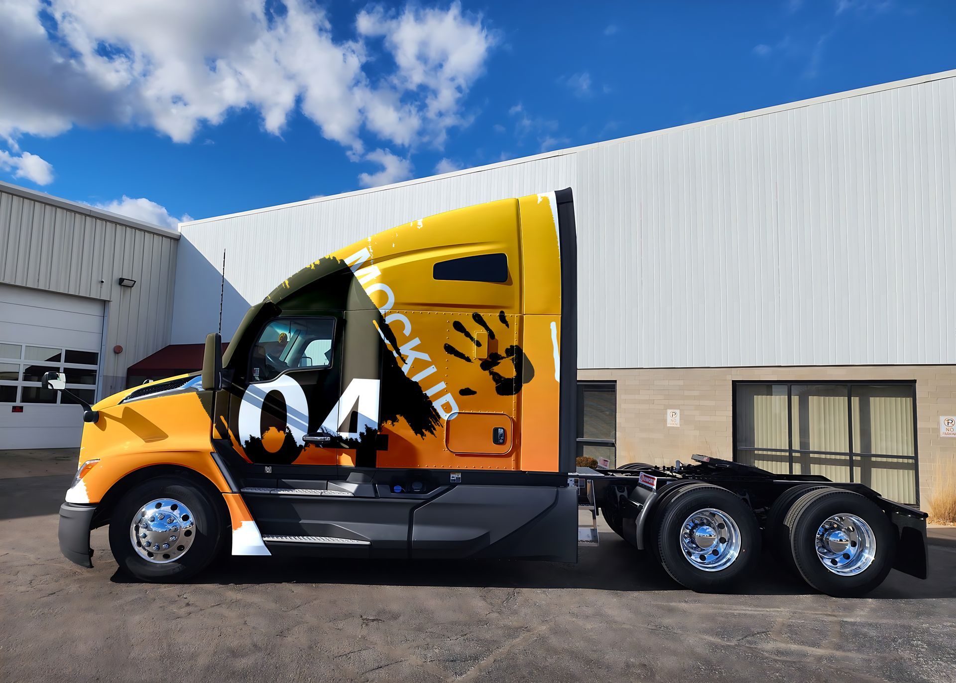 A yellow semi-truck with a black handprint and the number 04, parked outside a building under a blue sky.