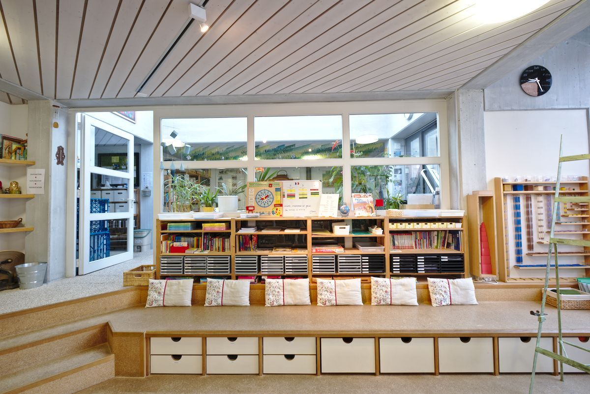 A room with a lot of shelves and drawers and a window.