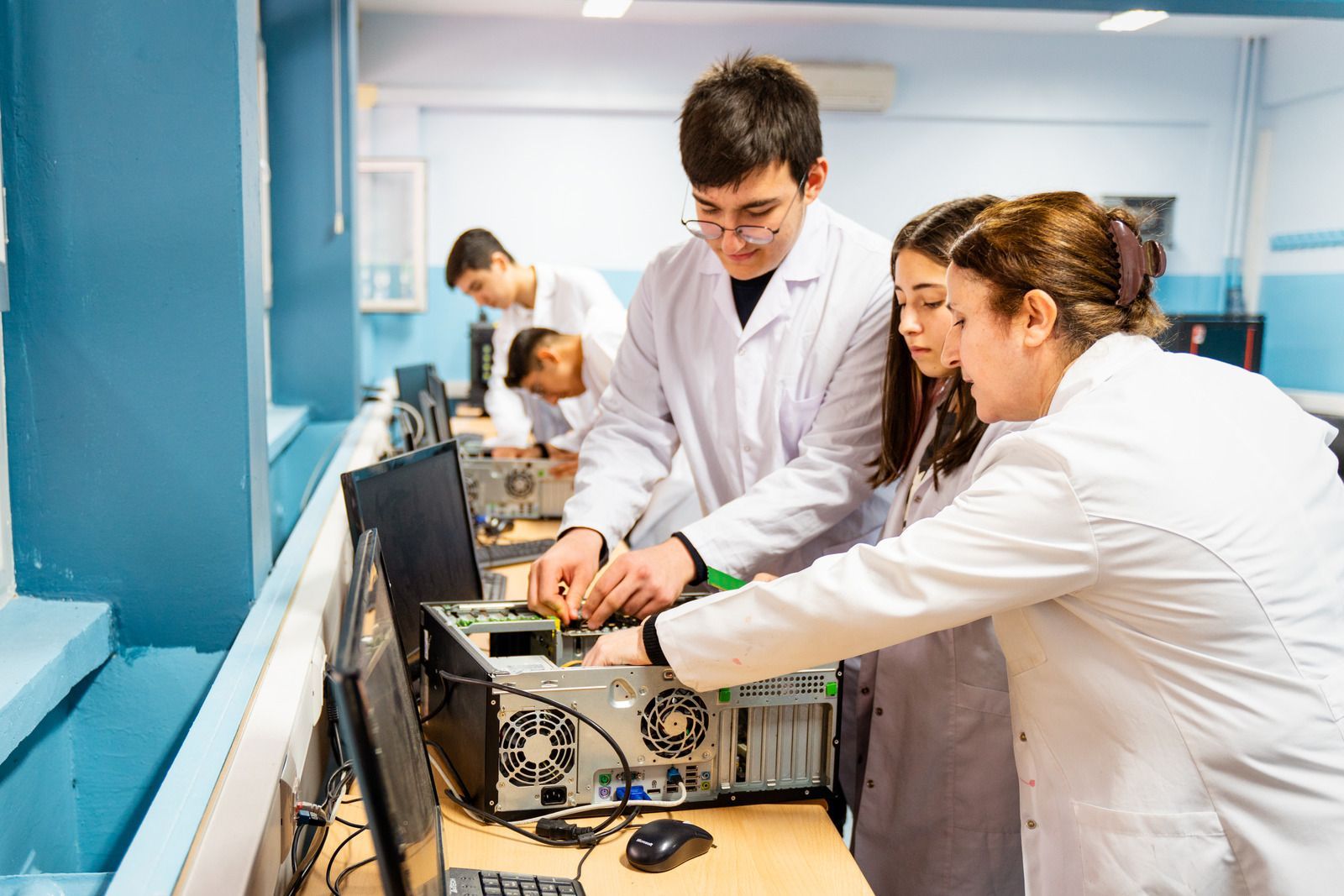 A group of people are working on a computer in a lab.