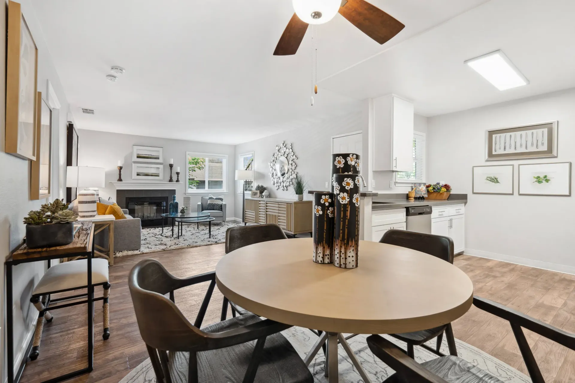 Open-concept living and dining area with round table and visible kitchen.