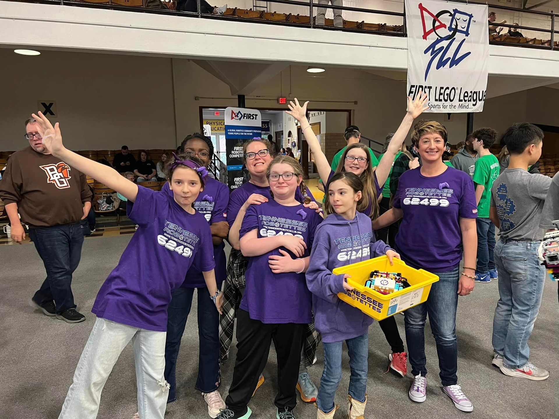 A group of children wearing purple shirts are posing for a picture.