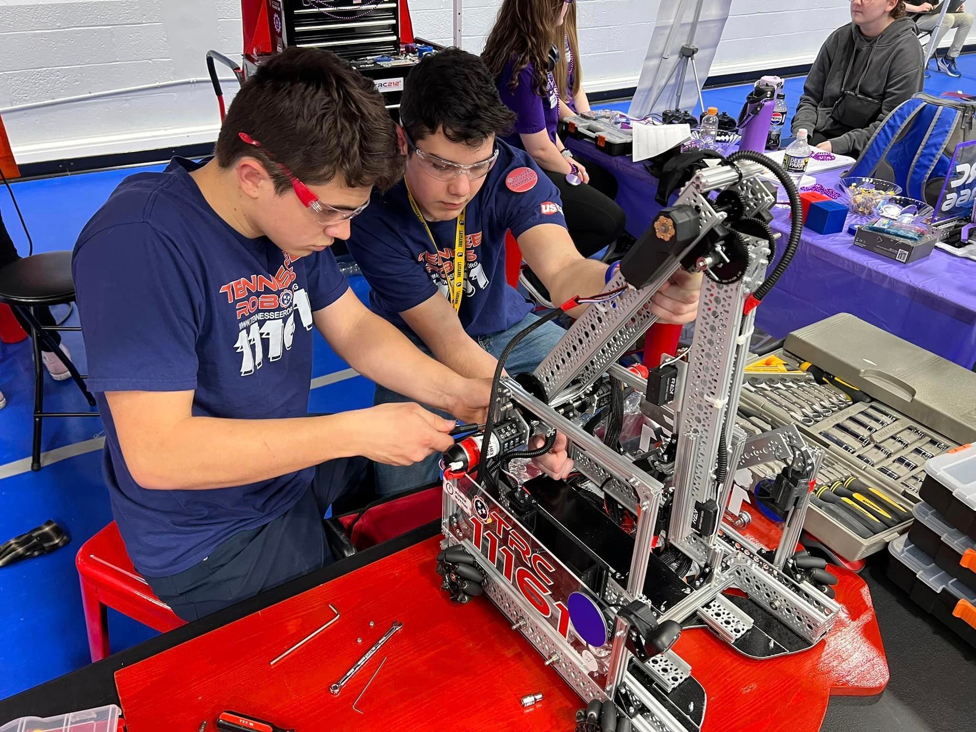 TRC students working on their robot at the competition.