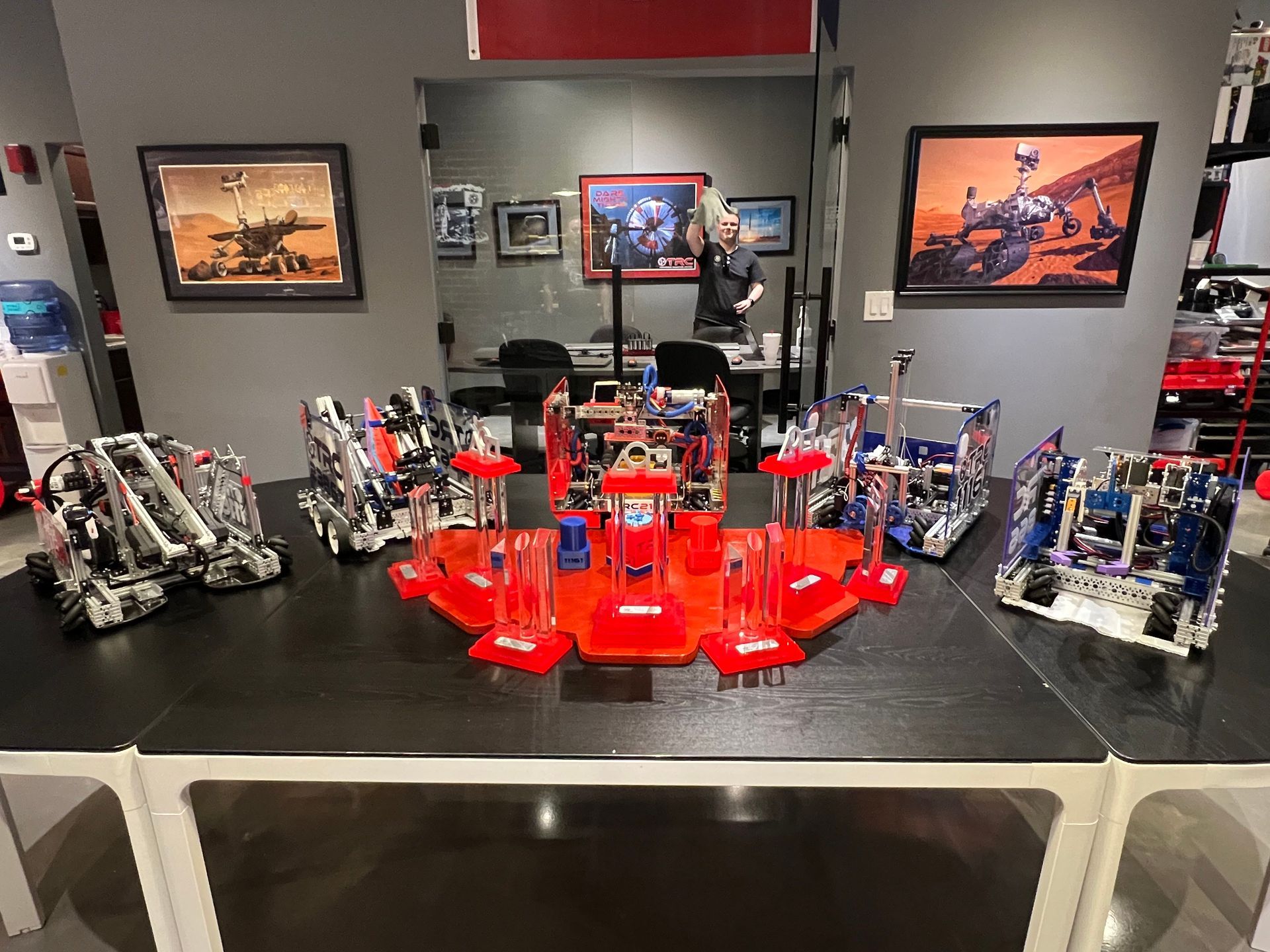 A group of robots are sitting on a table in a room.