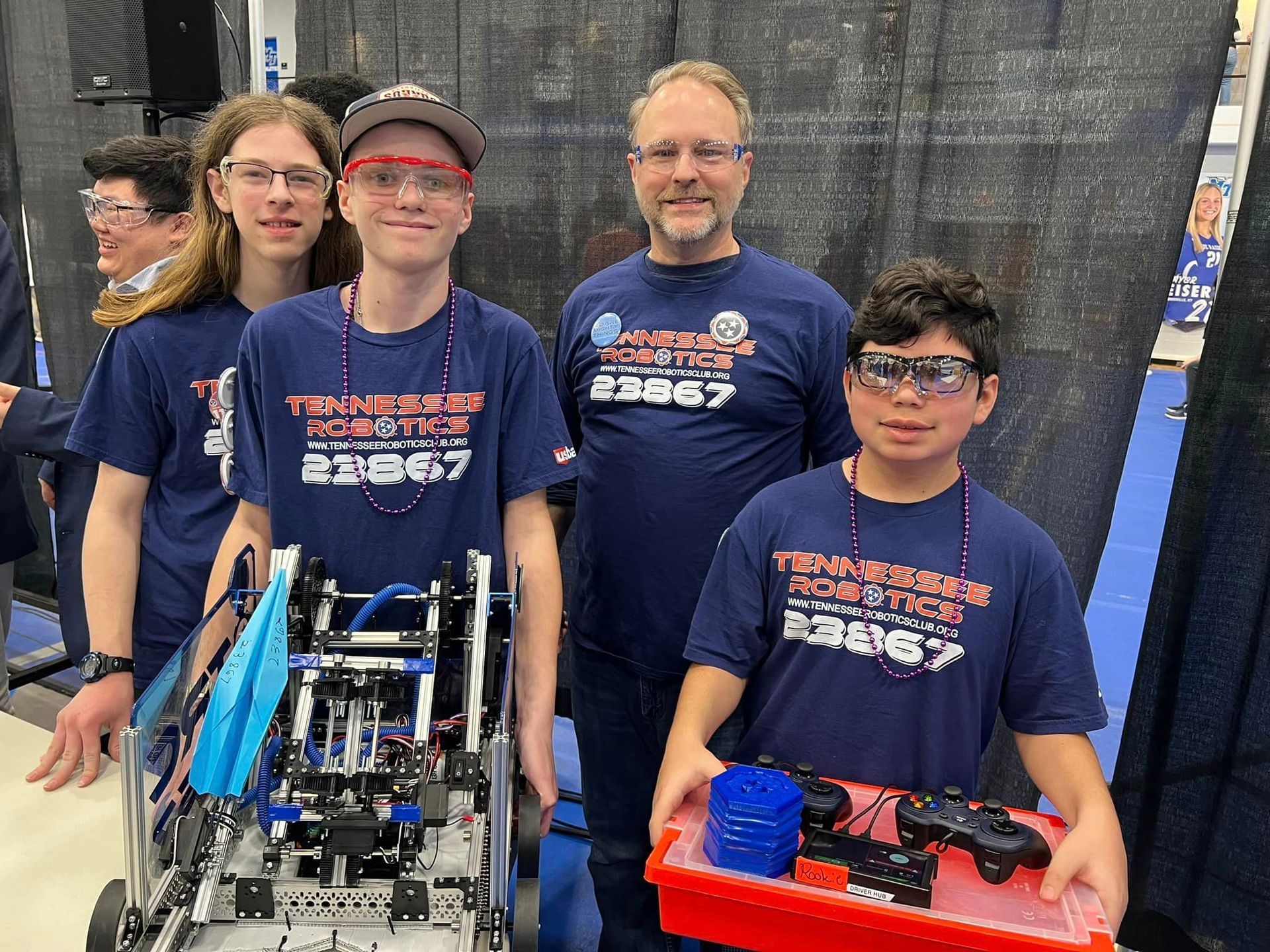 A group of young men are posing for a picture with a robot.