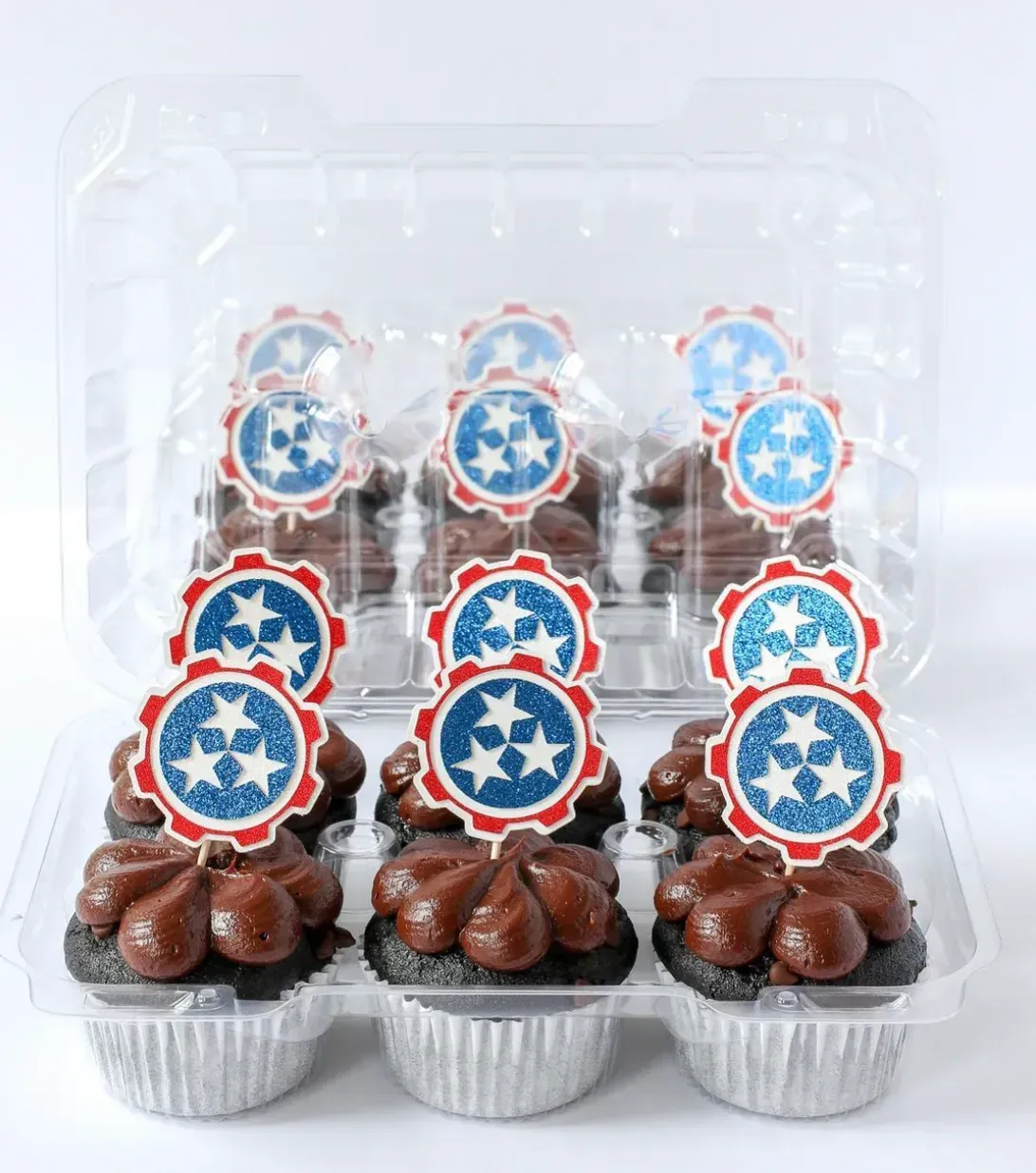 A tray of cupcakes with red white and blue stars on them