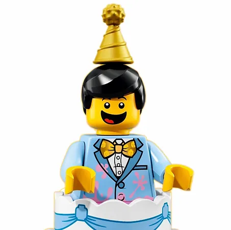 A lego man wearing a party hat is sitting on top of a birthday cake