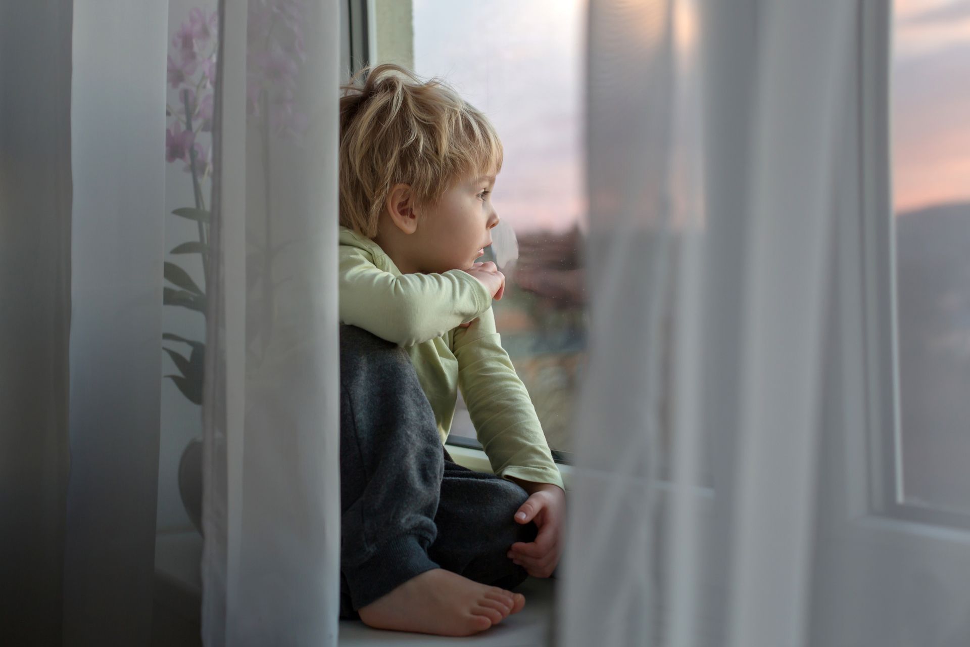 bambino che guarda fuori dalla finestra