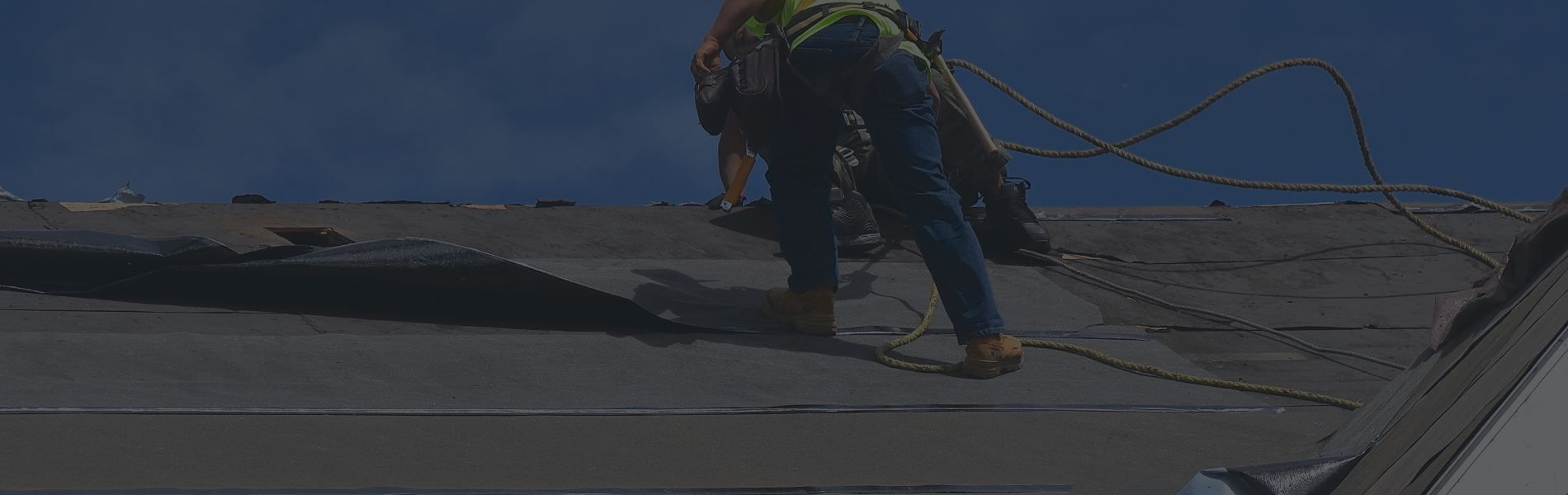 A person is walking on a beach with a skateboard.