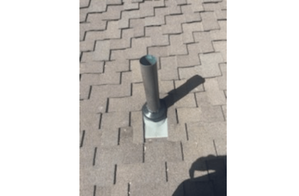 A metal pole is sitting on a brick sidewalk