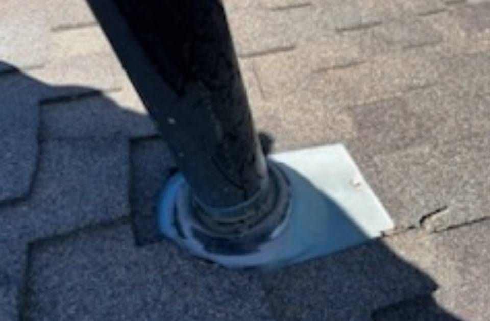 A black pipe is sitting on top of a roof.