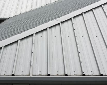 A close up of a white metal roof on a building.
