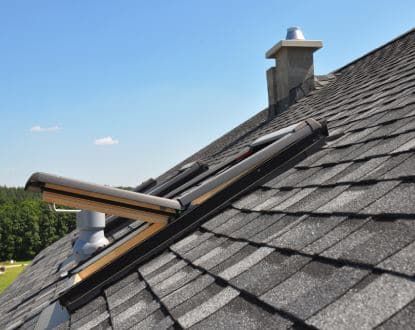 A roof with a skylight and a chimney on it.