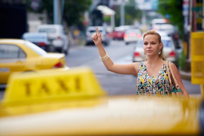 Woman in sundress hailing taxi