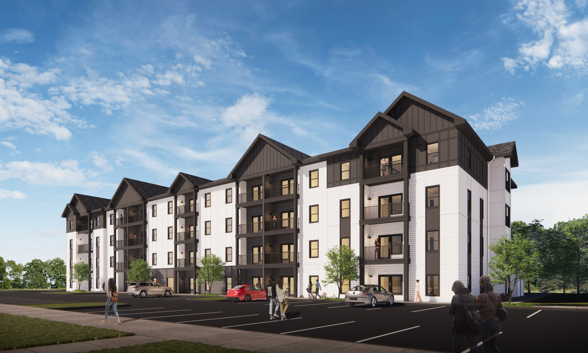 Modern apartment building with white siding, black trim, and gabled roofs under a blue sky.