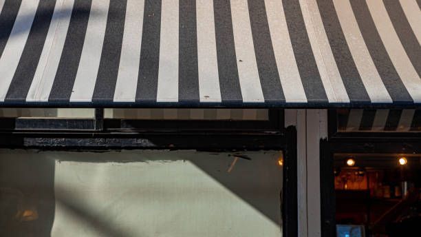 A Black And White Striped Awning Over A Store Window - 