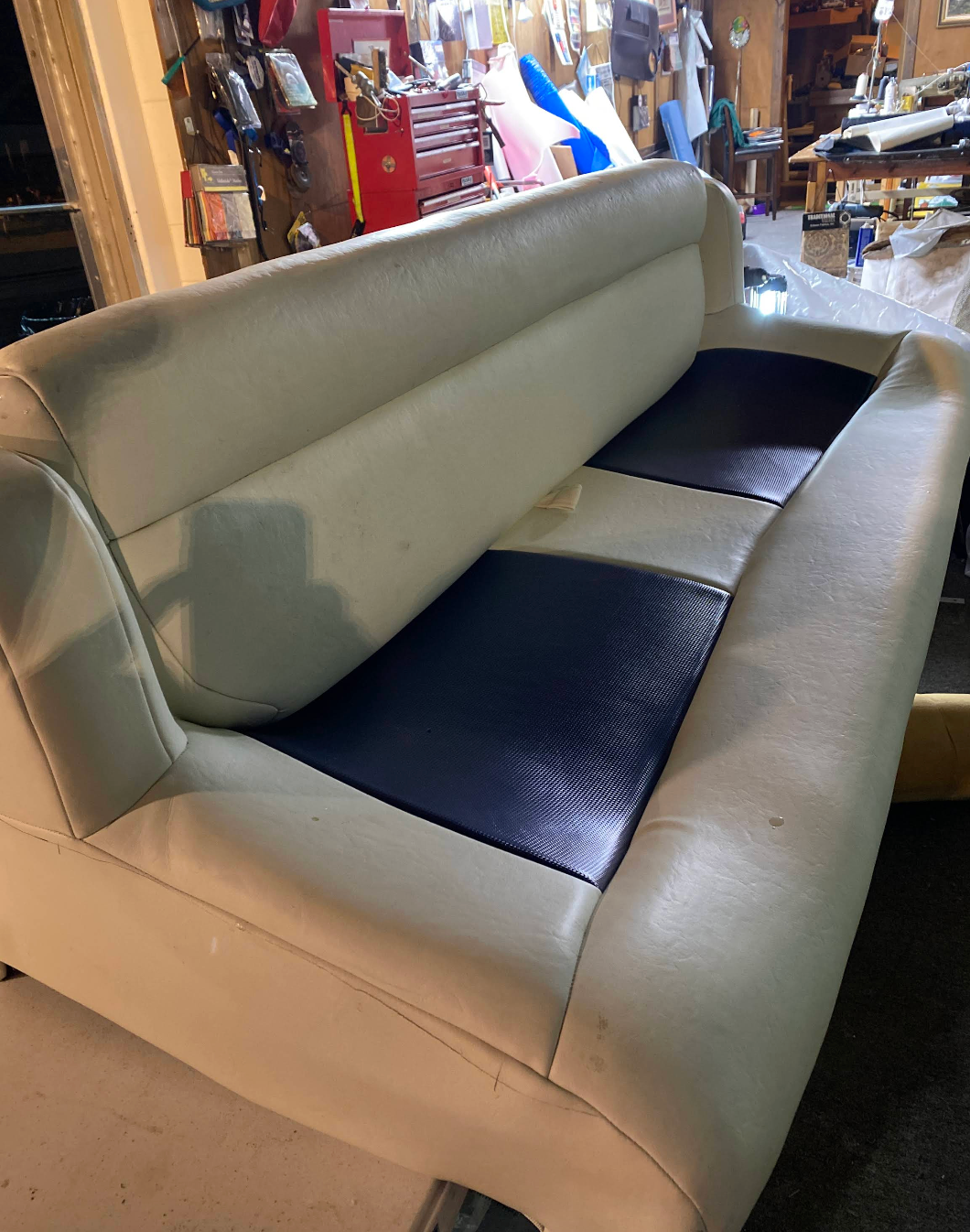 A white and blue couch is sitting in a room.