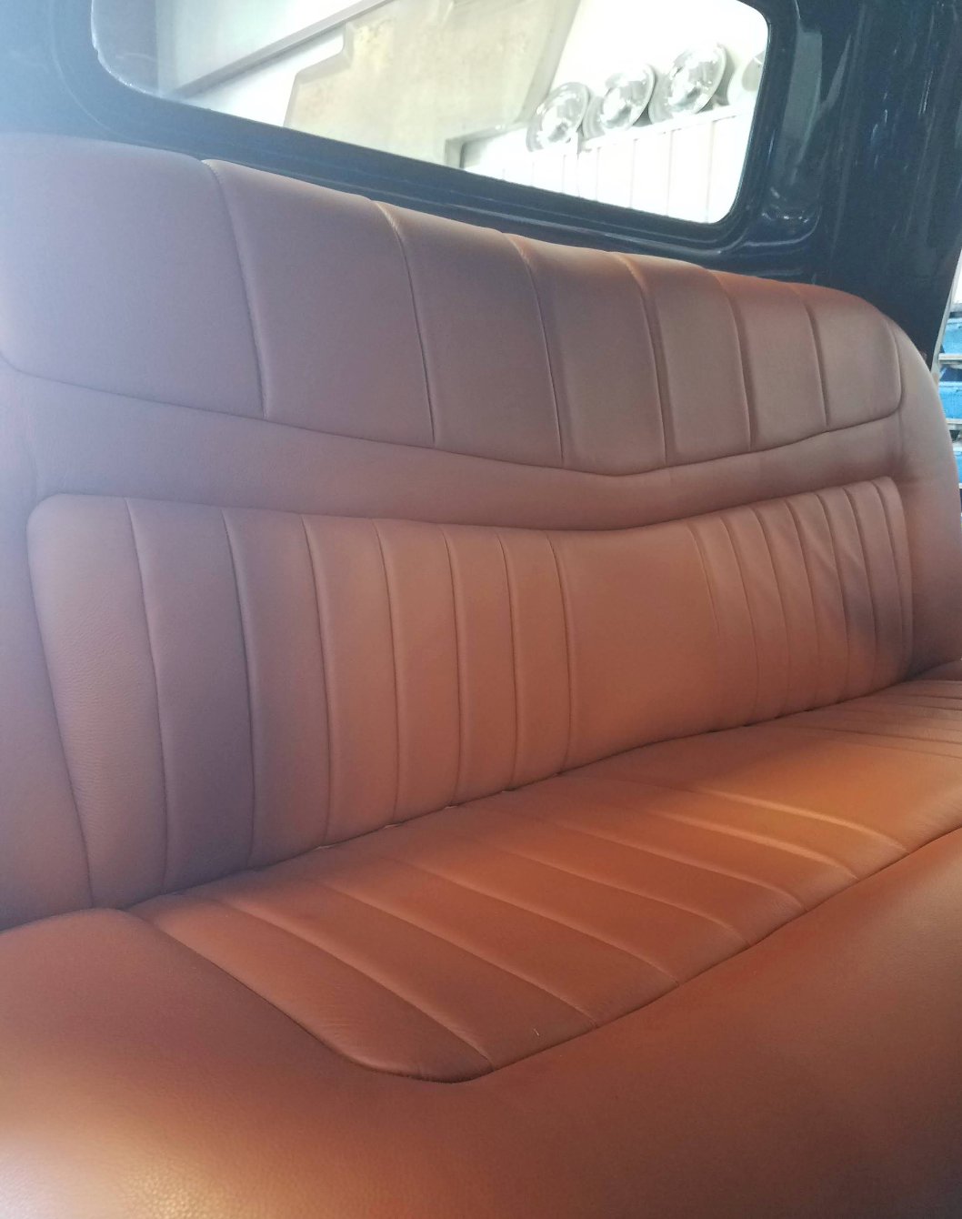 A close up of a brown leather seat in a car.