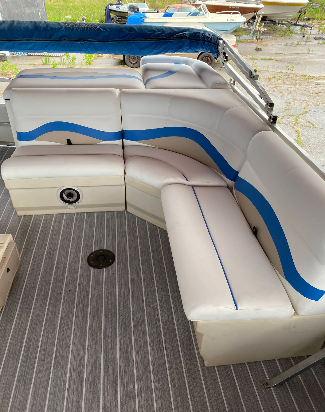 A boat with white and blue seats and a blue canopy